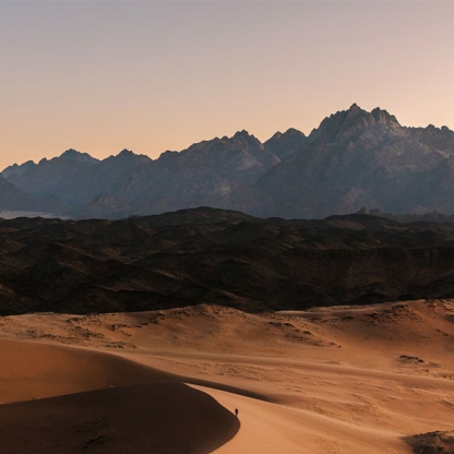 Photograph of Saudi desert with mountains in background
